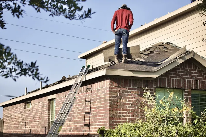 Professional roofer working on a residential roof in Schlusser